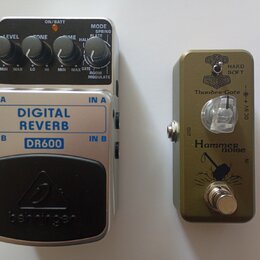 Dvě kytarové efektové pedály z ptačí perspektivy. Levý je stříbrný s černým spínacím pedálem a nápisy DIGITAL REVERB, DR600 a behringer. Má tři ovlád…