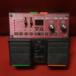 Červený looper s nápisy RC-30 DUAL TRACK LOOPER a LOOP STATION. Zařízení obsahuje několik ovládacích prvků, včetně posuvníků pro LOOP FX a potenciome…