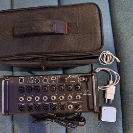 Černý digitální mixážní pult s nápisem X AIR XR16 a logem behringer. Zařízení obsahuje řadu vstupních konektorů, ovládacích prvků a USB port. Součást…