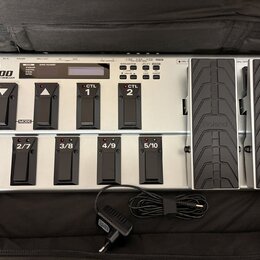 Stříbrný MIDI pedál s černými spínači a dvěma expresními pedály. Na zařízení je nápis Roland FC-300 MIDI FOOT CONTROLLER a na expresních pedálech log…