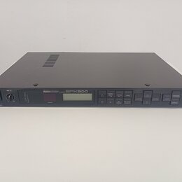 Šedý rackový efektový procesor s kovovým šasi. Na předním panelu je nápis YAMAHA MULTI-EFFECT PROCESSOR SPX900, malý displej a řada ovládacích tlačít…