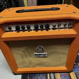 Kytarový kombozesilovač v oranžovém vinylu s černou rukojetí a rohymi. Na horním ovládacím panelu je nápis ORANGE, označení TH30 a řada ovladačů s po…