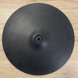 Černý gumový pad ve tvaru činely s koncentrickými drážkami. V horní části je vyražené logo Roland. Uprostřed se nachází otvor pro uchycení. Povrch vy…
