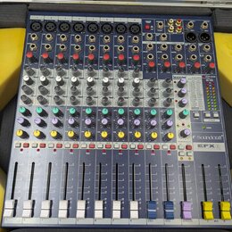 Modrý mixážní pult v hliníkovém kufru s pěnovou výplní. Na přístroji jsou vidět nápisy "exicon" a "Soundcraft EFX8". Zařízení obsahuje osm vstupních…