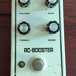 Bílý kytarový efekt s nápisem RC-BOOSTER a logem m.electronics v dolní části. Pedál má čtyři černé ovládací knoflíky s popisky VOLUME, GAIN, TREBLE a…