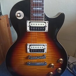 Elektrická kytara s trupem v barevnosti sunburst a černým pickguardem. Na přepínači je viditelný nápis RHYTHM TREBLE a na spodním snímači je nápis R.…