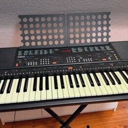 Černý digitální klavír s bílými klávesami a integrovaným notovým stojanem z perforovaného plastu. Na ovládacím panelu je viditelné logo YAMAHA a nápi…