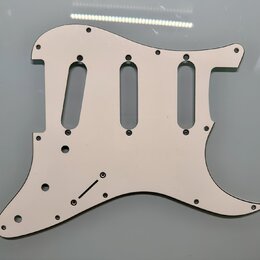 Bíle plastykový pickguard pro elektrickou kytaru s výřezy pro tři snímače. Povrch je hladký a čistý, bez viditelných značek, log nebo nápisů. Kolem o…
