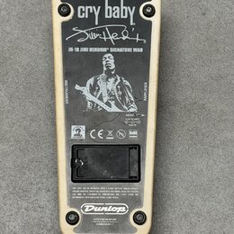 Zadní strana efekt pedálu s krémovým rámem a černým kovovým krytem. Na krytu je bílý nápis cry baby, podpis Jimi Hendrix a text JH-1B JIMI HENDRIX SI…