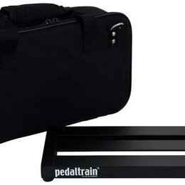 Černý přenosný kufr z textilie s rukojetí a zipem, na jehož boku je modrý štítek s nápisem pedaltrain. Vedle kufrů je černá kovová platforma pro efek…