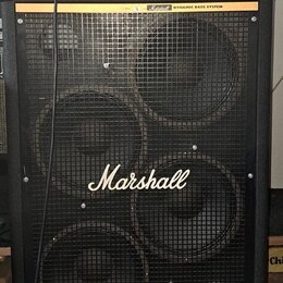 Černý basový kombozesilovač tvořený hlavou a reproboxem. Na obou částech je nápis Marshall DYNAMIC BASS SYSTEM a na přední mřížce boxu velké bílé log…