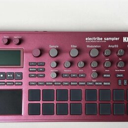 Bordeaux červený sampler KORG electribe sampler MUSIC PRODUCTION STATION. Zařízení obsahuje displej, několik otočných potenciometrů a mřížku šestiдес…