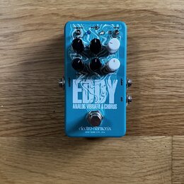 Modrý efekt pedál s bílým nápisem Eddy a textem ANALOG VIBRATO & CHORUS. Dole je uvedena značka electro-harmonix a nápis NEW YORK CITY, USA. Na horní…