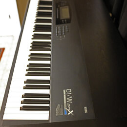 Černý digitální klavír s klasickou klávesnicí. Na pravé straně korpusu je nápis KORG a vedle něj označení 01/W ProX MUSIC WORKSTATION. V horní části…