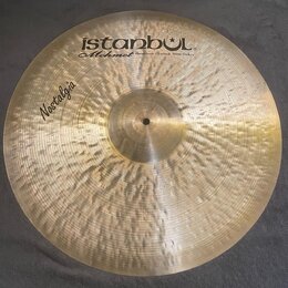 Kruhový mosazný činel s viditelným ručním klepaním povrchu. V horní části je černý nápis istanbul® a pod ním kurzívou Mehmet Handmade Cymbals from Tu…