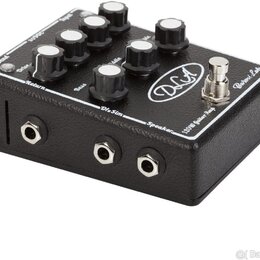 Černý kytarový předzesilovač v texturovaném pouzdře s bílými popisky. Na horní straně je nápis „DLA“, „Baroni Lab“ a „120W Guitar Amp“. Zařízení má n…