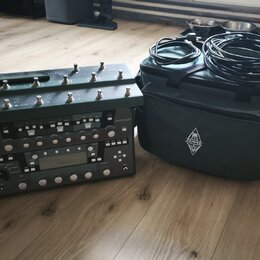 Na fotografii je kytarový procesor s ovládacím pedálem a přivázaným transportním kufrem v tmavě šedé barvě. Na horním panelu pedálu je nápis PROFILER…
