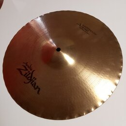 Zlatavý kovový činel s vlnovitým okrajem. Na povrchu je nápis „Avedis Zildjian“ a v horní části text „MASTERSOUND HI HAT BOTTOM 14"/35cm“. Povrch vyk…