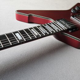 Elektrokytara s tmavě červeným lakem a bílým lemováním kolem korpusu. Hmatník je tmavý s velkými blokovými vložkami. Nástroj má dva humbuckery, dva o…