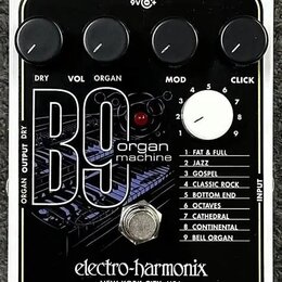 Kytarový efekt v bílém rámečku s černým povrchem. Na zařízení je nápis B9 organ machine a značka electro-harmonix NEW YORK CITY, USA. Obsahuje čtyři…