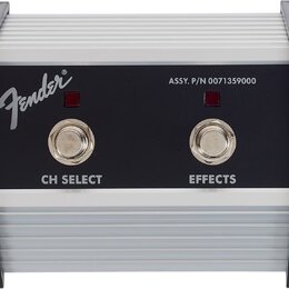 Stompbox s bílým žebrovaným šasi a černým předním panelem. Na panelu je bílé logo Fender, nápis ASSY. P/N 0071359000 a dva přepínače s popisky CH SEL…