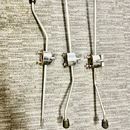 Tři kovové ladicí mechaniky stříbrné barvy s černými knoflíky. Jsou umístěny vedle sebe na šedém texturovaném povrchu. Na součástkách nejsou žádné vi…