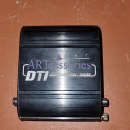 Černý obdélníkový box z kovu s žebrovaným povrchem. Na horní straně je bílý nápis „ART accessories series“ a pod ním označení „DTI“ s menším textem „…