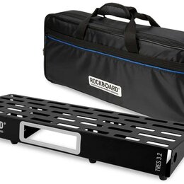 Černý pedalboard z kovového materiálu s perforovaným povrchem a bílým detailem v úhlu. Na boku jsou nápisy ROCKBOARD by WARWICK a TRES 3.2. Vedle ped…