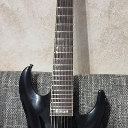 Černá elektrická kytara s tmavým hnedým hmatníkem. Na hlavě je bílý nápis LTD. Nástroj má dva humbuckery, jeden ovládací knoflík a přepínač. Povrch t…