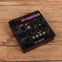 Černý string syntetizér s růžovými detaily a nápisy. Na horní části je velký nápis streichfett STRING SYNTHESIZER a v pravém dolním rohu logo waldorf…