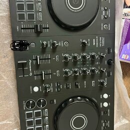 Černý DJ kontrolér s dvěma velkými jog-koly astředovými tlačítky. Na přístroji je vidět nápis Pioneer DJ a označení modelu DDJ-FLX4. Povrch obsahuje…