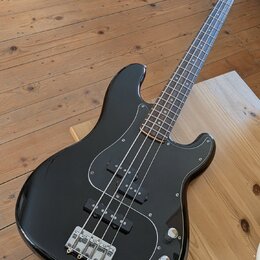 Černý elektrický basový kytara s černým pickguardem a hnedým hmatníkem. Na hlavě nástroje je bílé logo Epiphone. Nástroj má dva snímače, čtyři ovláda…