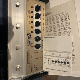 Kremové kytarové pedály v hliníkovém šasi s nápisy TECH 21 NYC, SansAmp a Blonde DELUXE. Zařízení má pět otočných ovladačů s popisky DRIVE, CHARACTER…
