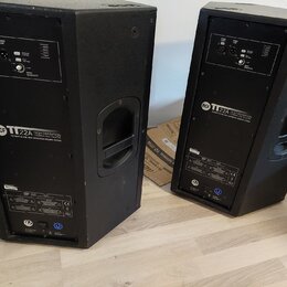 Dva černé aktivní reproduktory v plastových bednách s úchopovými madly. Na zadním panelu obou kusů je bílý nápis RCF TT 22A HIGH DEFINITION TOUR LINE…