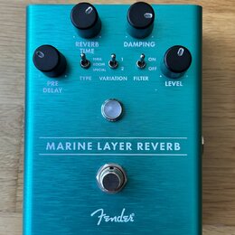 Tyrkysový efekt pedál s kovovým povrchem. Na přední straně jsou čtyři černé ovládací knoflíky s popisky PRE DELAY, REVERB TIME, DAMPING a LEVEL, tři…