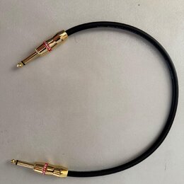 Černý instrumentální kabel s pozlacenými konektory typu 6,35 mm jack. Na červených kroužcích u obou konektorů je bílý nápis MONSTER. Na izolaci kabel…