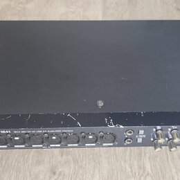 Černý audio rozhraní v kovovém šasi. Na předním panelu je nápis TASCAM US-1641 16x4 96k/24-bit USB 2.0 Audio/MIDI Interface a červený svítící indikát…