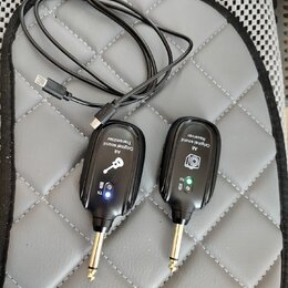 Dva černé bezdrátové vysílače s kovovými konektory typu jack. Na levém je nápis „A8 Original sound Transmitter“ a symbol klíče, na pravém „A8 Origina…