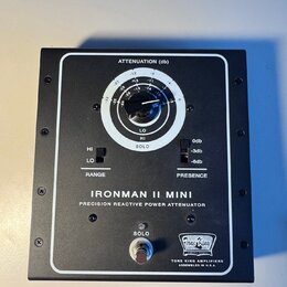 Černý power attenuator s bílými nápisy a ovládacími prvky. Na předním panelu je velký otočný knoflík s nápisem ATTENUATION (db) a stupnicí od 0 do -3…