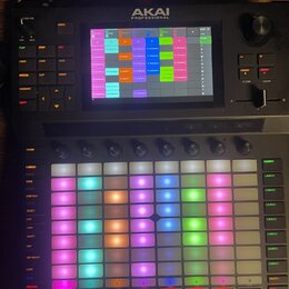 Černý kontrolér s nápisem AKAI PROFESSIONAL. Zařízení obsahuje barevně podsvícenou mřížku padů, několik otočných knoflíků a digitální displej s rozhr…