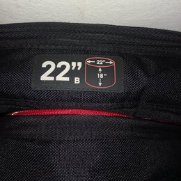 Detail černé texturované látky s přišitou černou štítkem. Na štítku je bílý nápis 22" B a schéma obdélníku s rozměry 22" a 18". Pod štítkem je vidite…