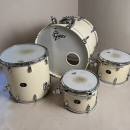 Sada bicích bubnů v krémové barvě s chromovaným hardwarem. Na přední kožeh basového bubnu je černé logo GRETSCH. Ostatní bubny mají na korpusu malé č…