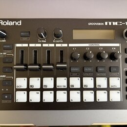 Černá groovebox s bílými nápisy a logem Roland. V pravém horním rohu je modelové označení GROOVEBOX MC-101. Zařízení obsahuje displej, několik otočný…