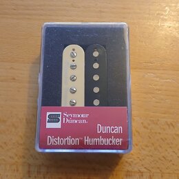 V průhledném plastovém obalu jsou dva humbuckery, jeden v krémové a druhý v černé barvě. Na červeném štítku je uveden nápis Seymour Duncan, Duncan Di…