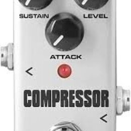 Bílý efekt pedál s nápisem COMPRESSOR a značkou KOKKO v dolní části. Pedál má tři černé ovládací knoflíky s popisky SUSTAIN, LEVEL a ATTACK. Uprostře…
