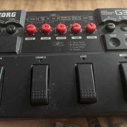 Černý kytarový procesor s nápisem KORG a označením GUITAR PERFORMANCE PROCESSOR G3. Zařízení má pět červených otočných ovladačů s popisky DRIVE, TONE…