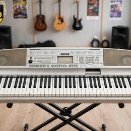 Stříbrošedý digitální klavír značky YAMAHA umístěný na černém X-stojanu. Na horním panelu je uprostřed logo YAMAHA a vpravo nápis graded Zram. Nástro…