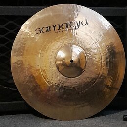 Kruhový mosazný činel s viditelným kovánívým povrchem. V horní části je černý nápis „samatyu“ a pod ním menší nápis „series“. Povrch vykazuje drobné…