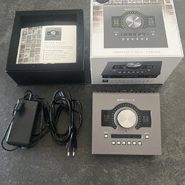 Fotografie zobrazuje audio rozhraní stříbrné barvy s nápisem apollo twin | x a logem UNIVERSAL AUDIO. Součástí je originální bílá krabice s nápisy LU…