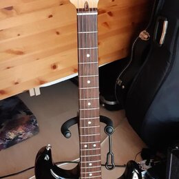 Elektrická kytara typu Stratocaster s korpusem v přechodové barvě od černé k hnědé a žluté. Má bílý pickguard, tři snímače a javorový krk s hmatníkem…